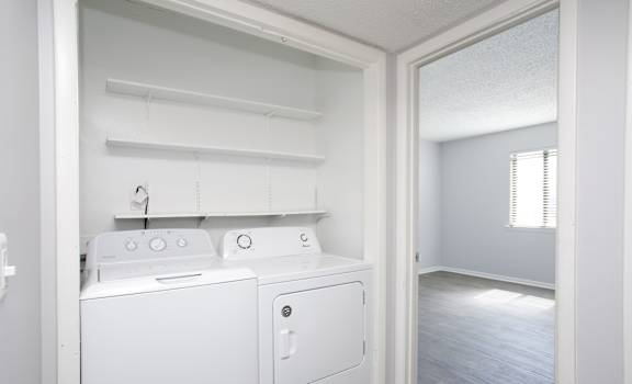 an empty laundry room with a washer and dryer in it