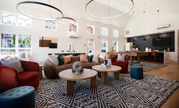 A living room with a patterned rug and a variety of seating options. at The Mill on Maple Apartments, Oregon City, OR 97045