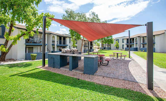 a patio with a picnic table and a red canopy