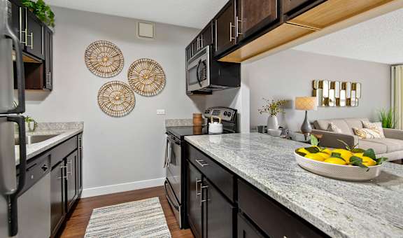 A kitchen with a granite countertop and stainless steel appliances.
