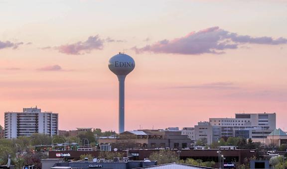 A cityscape with a tall tower in the center and the word "Edina" on it.