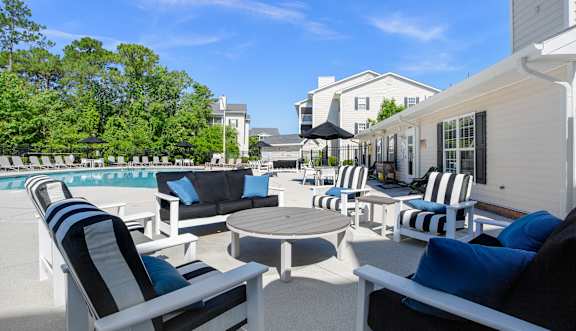 A patio with black and white striped chairs and a round table.