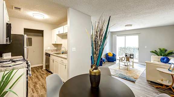 A modern kitchen with a dining table and chairs at Sedgefield Square Apartments, North Carolina, 27407