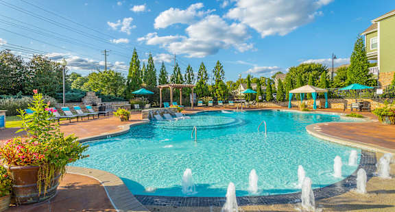 A large swimming pool with a fountain in the middle of it.
