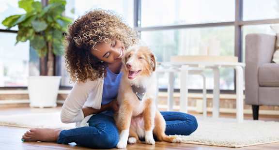 a woman sitting on the floor with a dog