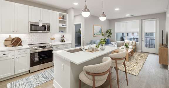 A modern kitchen with white cabinets and a large island. at The Sully, Chantilly, Virginia
