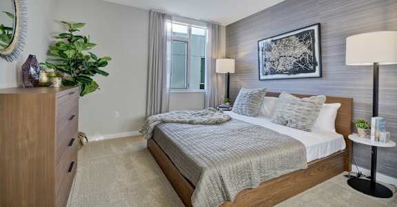 a bedroom with a bed and a dresser and a window at L Seven, CA 94103