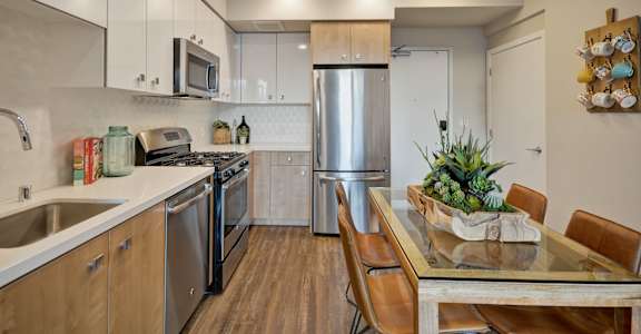 a kitchen with stainless steel appliances and a table with chairs at L Seven, CA 94103