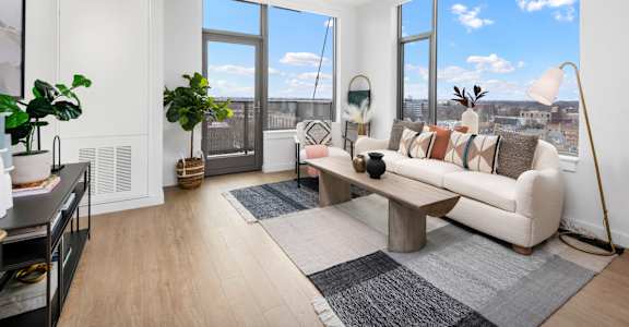 A living room with a large window and a view of the city.