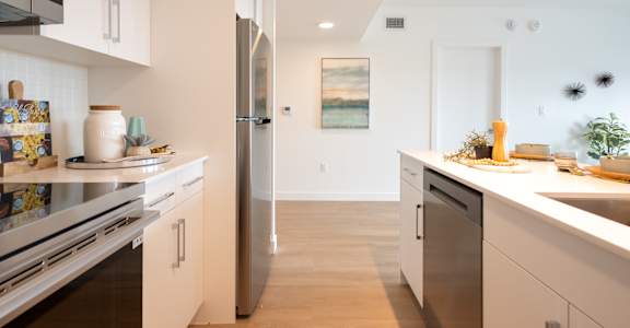 A modern kitchen with a refrigerator, oven, and sink.