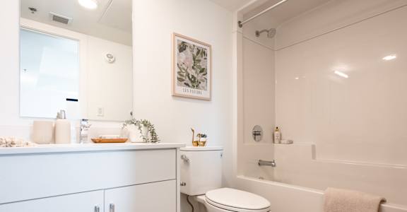A white bathroom with a toilet, sink, and bathtub.