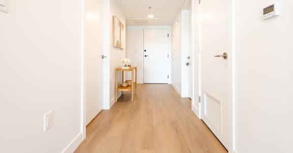 A long hallway with a table and chairs in the middle.