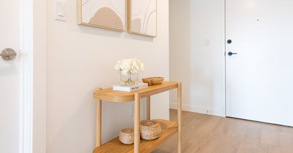 A table with a vase of flowers and a basket on it.