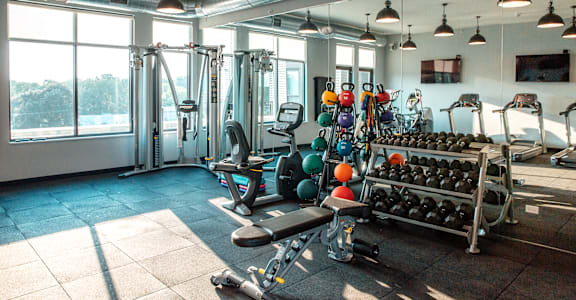 a workout room with weights and a large window