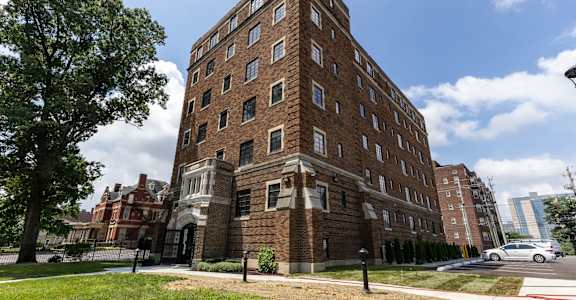 A large red brick building with a tree in front of it.