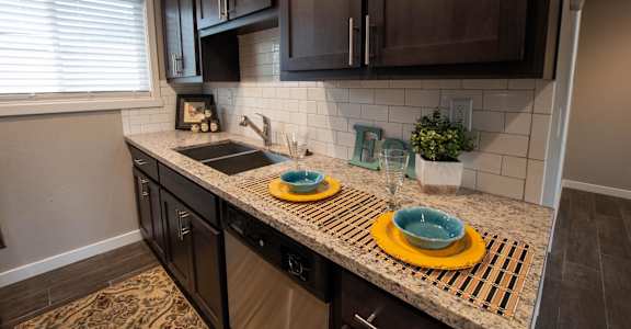 Kitchen with granite counters, wood cabinets, and double sink