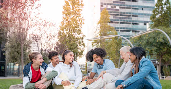 A group of friends sitting on the grass in a park.