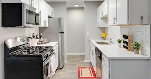 a kitchen with white cabinets and a stove and a refrigerator