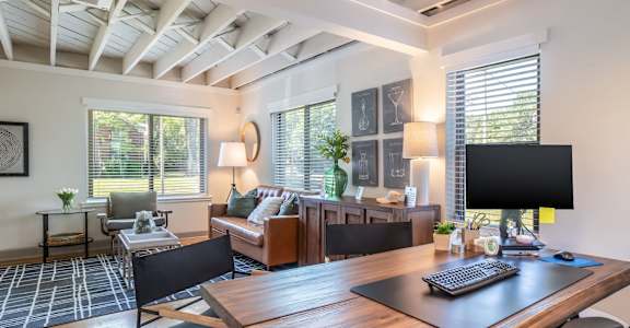 A modern home office with a wooden desk and black chairs at Kiwi Goji Apartments, Memphis, 38111