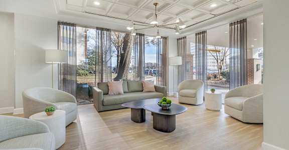 A spacious living room with a large window and a view of trees outside.