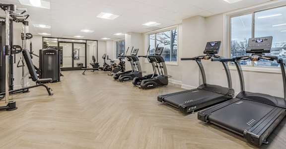 A gym with treadmills and other exercise equipment.
