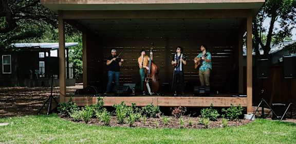 a group of people standing on a stage in a shed