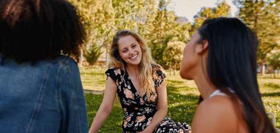 Three women having a picnic in a park.