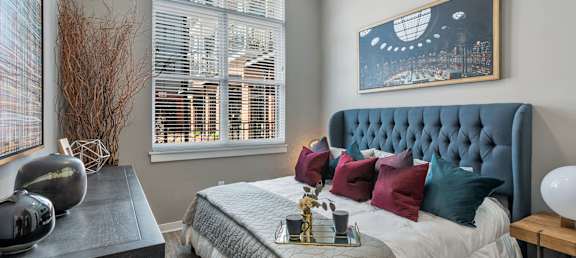 a bedroom with a large bed and two windows