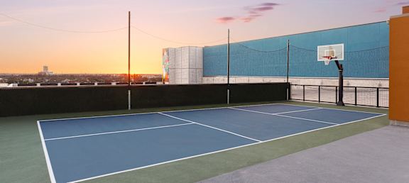 a tennis court on the roof of a building with a sunset in the background