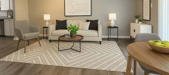 A living room with a white couch, a coffee table, and a ceiling fan.