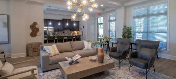 A living room with a large couch, a coffee table, and a chandelier. at Hall Creek Apartment Homes, Arlington, Tennessee