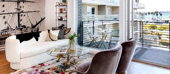 A living room with a white couch and a glass table.