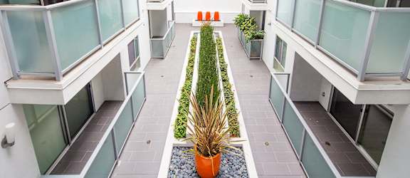 an indoor courtyard in an apartment building with potted plants