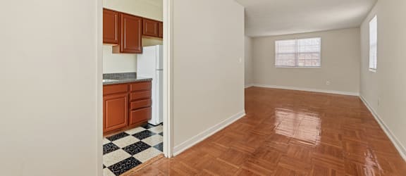 A kitchen with wooden floors and a checkered floor mat.
