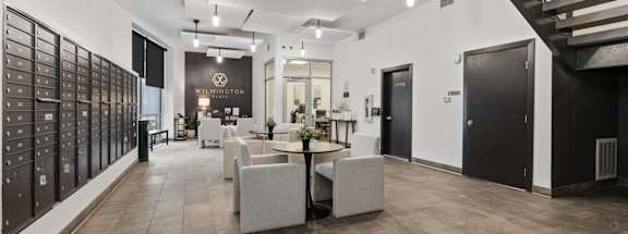 A spacious interior with a staircase on the right and a long wall of mailboxes on the left. at Wilmington Flats Apartments, Salt Lake City, UT, 84106