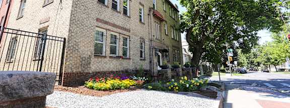 A building with a black fence and a gravel area in front.
