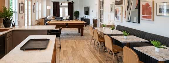 A modern kitchen and dining area with wooden floors and furniture at Ansley at Town Center Apartments, Evans, GA 30809