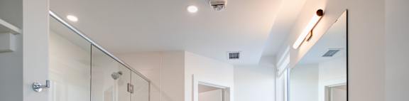 a white bathroom with a shower and a sink