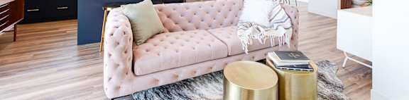 a living room and kitchen with a pink couch
