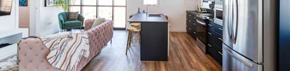 a kitchen and living room with a stainless steel refrigerator