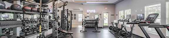 A spacious gym with treadmills, weights, and exercise equipment.