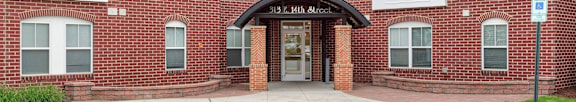 the entrance to a brick building with a sidewalk in front of it