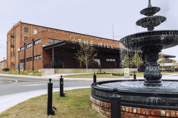 a fountain in front of a large brick building  at The Mill at Prattville, Alabama