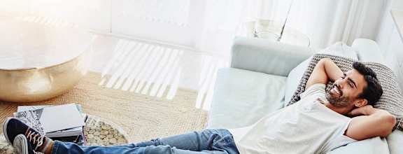 a man laying on a couch in a living room