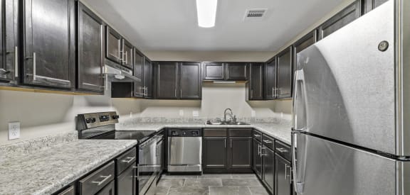 Pecan Acres renovated kitchen with stainless steel appliances, granite style countertops, and tile flooring