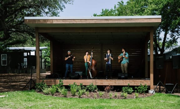 a group of people standing on a stage in a shed