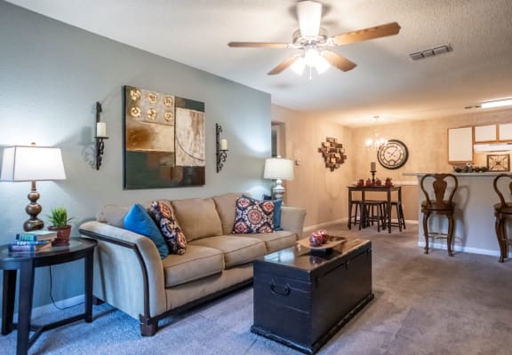 a living room with a couch and a ceiling fan at The Summit Apartments, Memphis, Tennessee