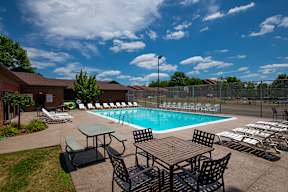 A pool area with a table and chairs.