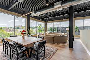 A dining room with a table and chairs and a view of the city.