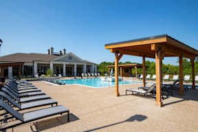 A pool area with sun loungers and a wooden pavilion at Grays Creek Apartments, Cordova, TN